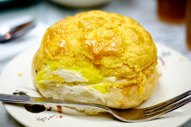 7. 菠蘿包 Pineapple Bun
說到茶餐廳美食,當然不能忘記菠蘿包!這種沒有餡料的甜麵包,發跡於 1960 年代的香港,因烘烤後,金黃凹凸的脆皮狀似菠蘿而得名。
這種麵包趁熱吃最美味,另外,也推薦可以點份夾了因熱融化的冰奶油的冰火波蘿包來嚐嚐。